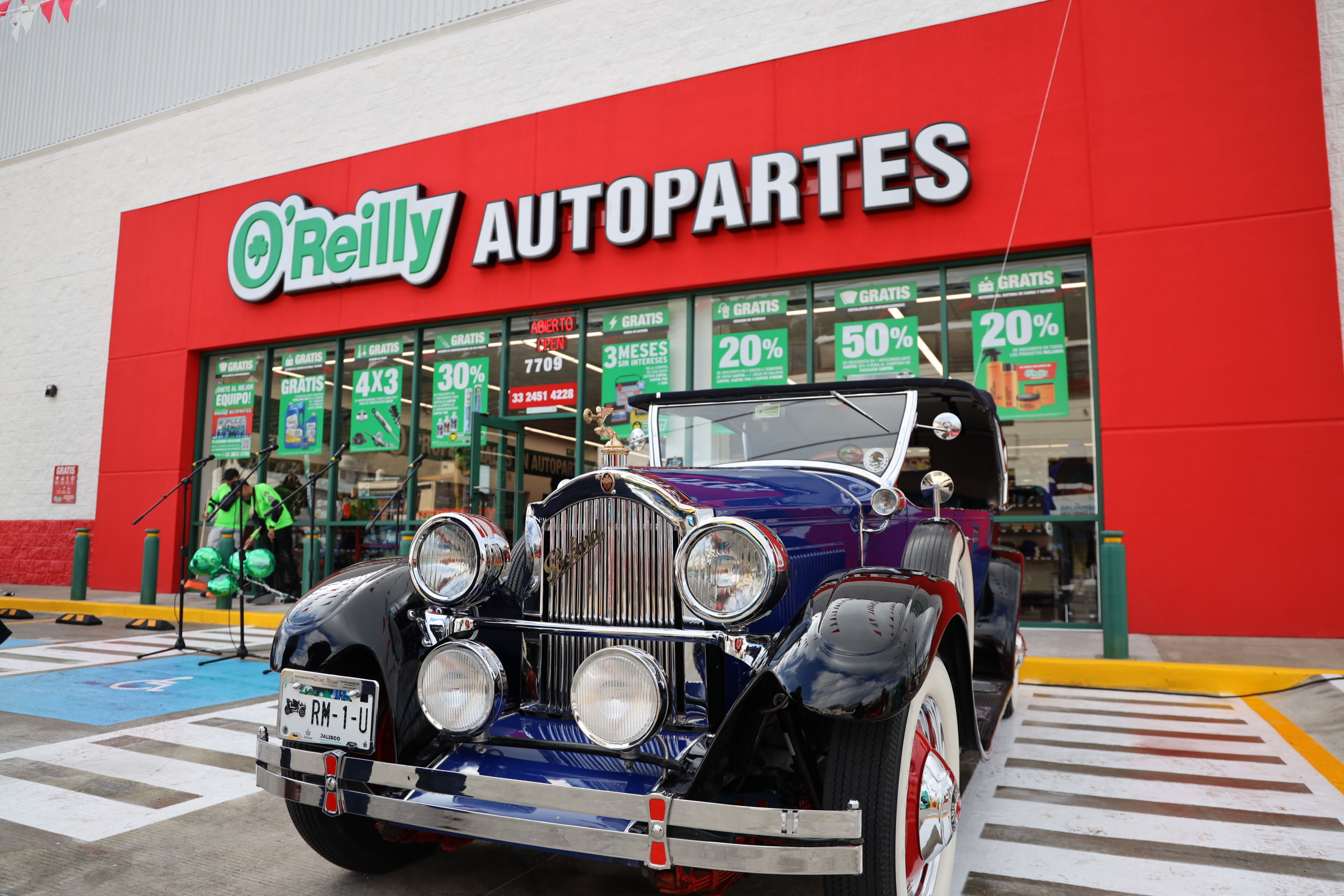 A vintage automobile sits outside an O'Reilly Auto Parts store in Mexico.